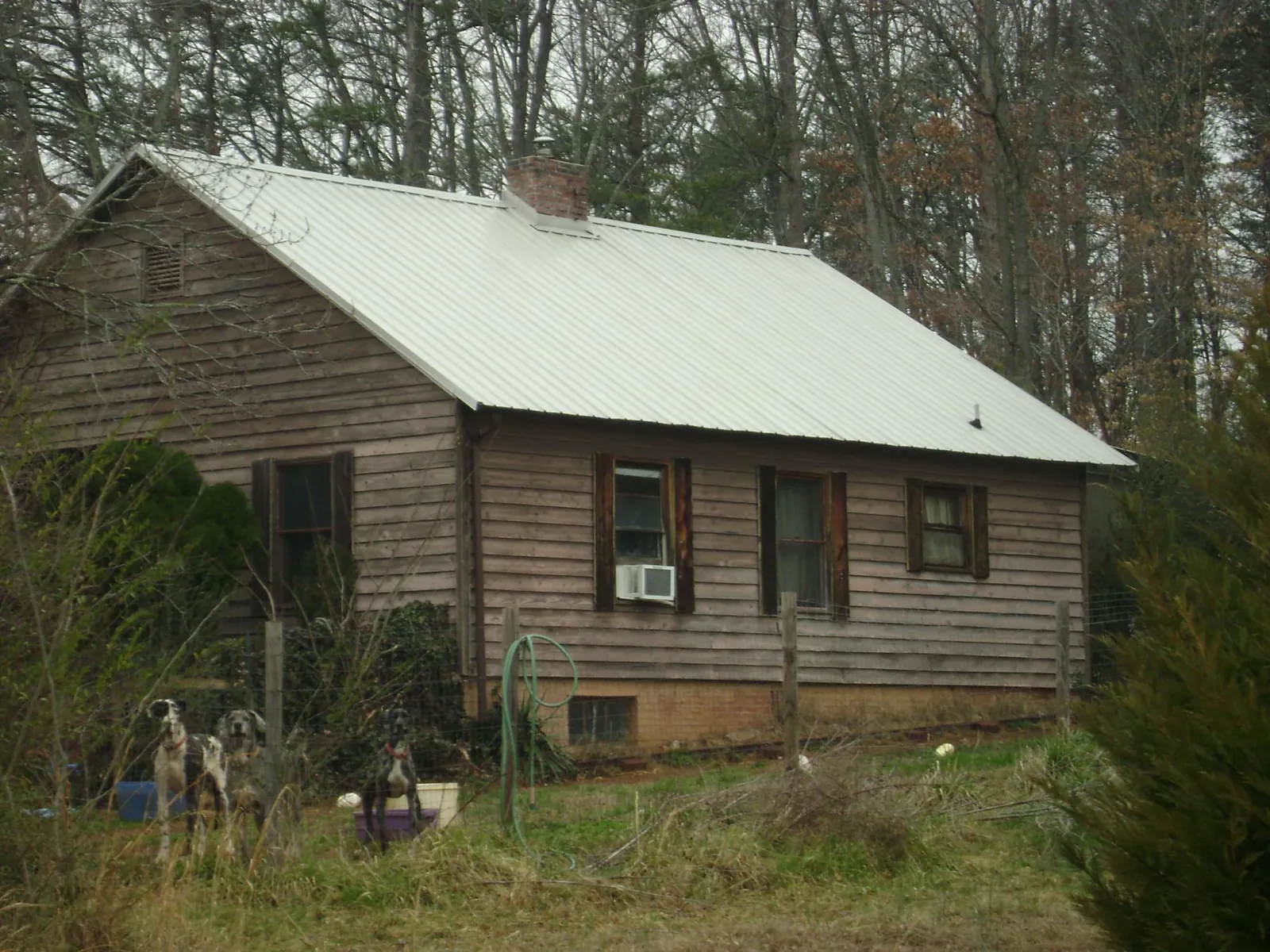 White metal roof on an old wood sided farmhouse, from a Metal Roof Installation job in Troy